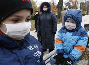 Children wearing protective masks play in central square in Kiev
